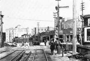 Mott Avenue crossing at grade.  Depot at right of MU train.  Express house towers above the lead car in the background.  Looking east - 1915.jpg (104323 bytes)